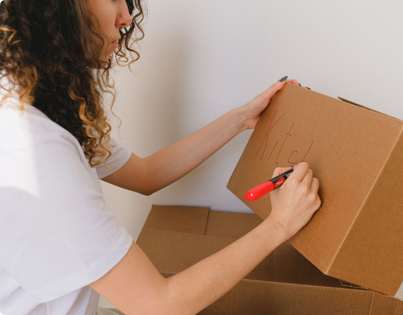 Student labeling a box before storage